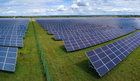Aerial view of large sustainable electrical power plant with rows of solar photovoltaic panels for...