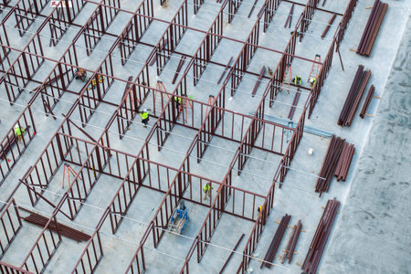 Construction site with hardhat workers assembling metal frame walls. Aerial view of large development area of commercial structure. Real estate market in the USAの写真素材