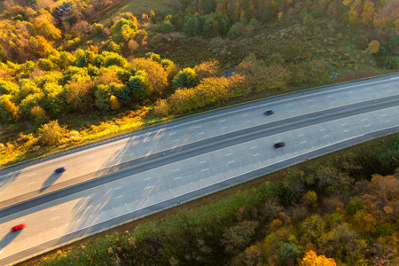 Elevated view of freeway road lanes with fast moving traffic cars and trucks. Interstate...
