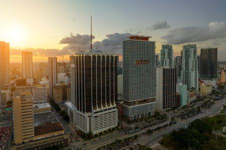 Evening urban landscape of downtown district of Miami Brickell in Florida USA. Skyline with dark high skyscraper buildings and street with cars and Metrorail traffic in modern american megapolisの写真素材