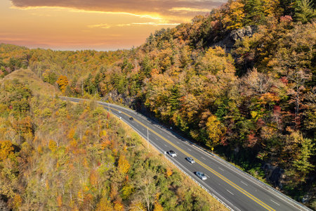 Elevated view of freeway road lanes between autumn mountain hills. Interstate transportation...