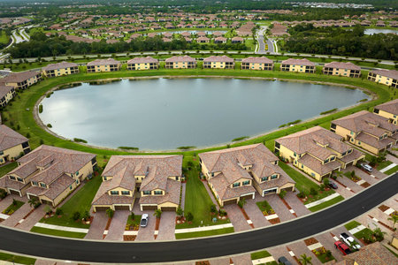 View from above of densely built residential houses near retention ponds in closed living clubs in south Florida. American dream homes as example of real estate development in US suburbsの写真素材