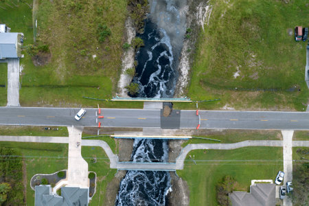 Repair of destroyed bridge after hurricane flood in Florida. Reconstruction of damaged road after flooding water washed away asphalt. Construction roadwork siteの写真素材