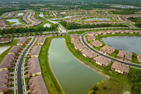 View from above of densely built residential houses near retention ponds in closed living clubs in south Florida. American dream homes as example of real estate development in US suburbsの写真素材