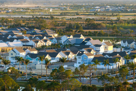 Unfinished frames of inexpensive homes with wooden roof beams under construction. Development of residential housing in US suburbs. Real estate market in the USAの写真素材