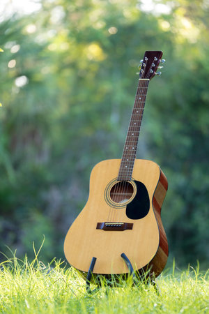 Acoustic guitar outdoors on greenery background. Concept of calm musicの写真素材