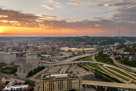 Aerial view of American highway junction at sunset with fast driving vehicles in Cincinnati city, Ohio. View from above of USA transportation infrastructureの写真素材