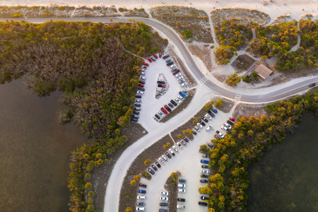 Aerial view of cars parked on ocean beach parking lot. Vacation on beachfront in Southern Florida