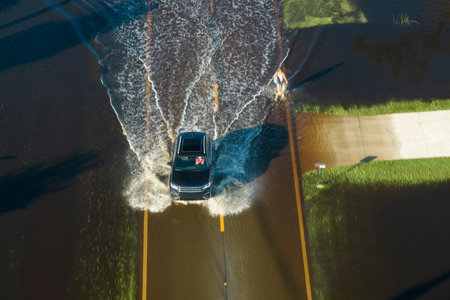 Aerial view of flooded street after hurricane rainfall with driving cars in Florida residential area. Consequences of natural disasterの写真素材