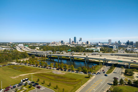 Aerial view of Jacksonville city with high office buildings and american freeway intersection with fast moving cars and trucks. USA transportation infrastructure conceptの写真素材