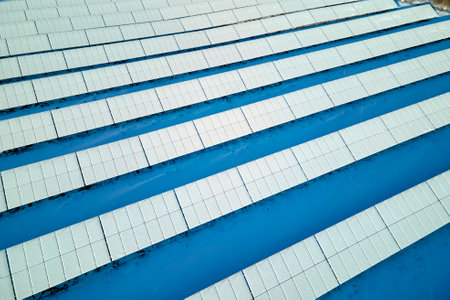 Aerial view of electrical power plant with solar photovoltaic panels covered with snow in winter for producing clean energy. Concept of low effectivity of renewable electricity in northの写真素材