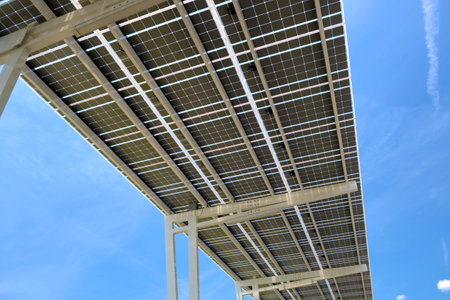 Solar panels installed over parking lot canopy shade for parked cars for effective generation of clean energyの写真素材