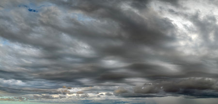 Stormy cumulus clouds forming during heavy thunderstorm on dark sky. Moving and changing cloudscape weatherの写真素材