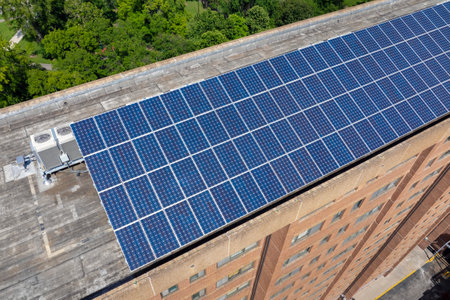 Apartment building with solar roof. Blue photovoltaic panels for producing clean ecological electric...