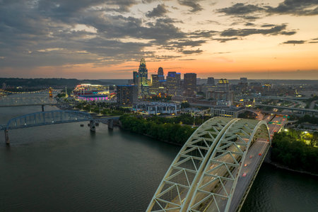 Night urban landscape of downtown district of Cincinnati city in Ohio, USA. Skyline with driving cars on bridge and brightly illuminated high skyscraper buildings in modern American megapolisの写真素材