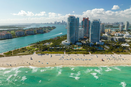 Tourism infrastructure in southern USA. South Beach sandy surface with tourists relaxing on hot Florida sun. Miami Beach city with high luxury hotels and condosの写真素材