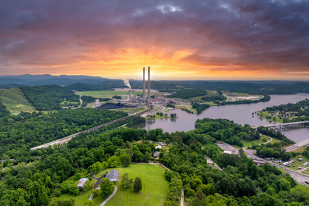 Toxic emissions from thermal power plant polluting air in city suburbs. Electricity production by burning coal fossil fuel.の写真素材