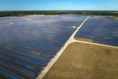 Aerial view of big sustainable electric power plant with many rows of solar photovoltaic panels for producing clean electrical energy. Renewable electricity with zero emission conceptの写真素材