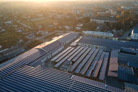 Aerial view of blue photovoltaic solar panels mounted on industrial building roof for producing green ecological electricity. Production of sustainable energy conceptの写真素材
