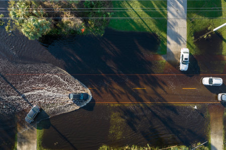 Aerial view of flooded street after hurricane rainfall with driving cars in Florida residential area. Consequences of natural disasterの写真素材