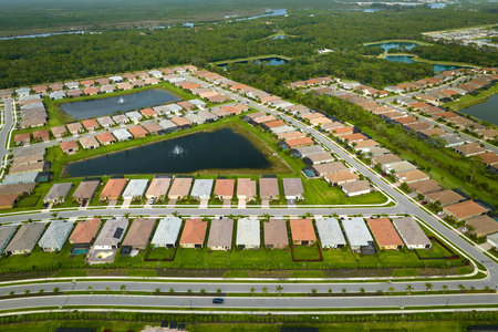 Aerial view of tightly packed homes in Florida closed living clubs with lake water in the middle. Family houses as example of real estate development in american suburbsの写真素材