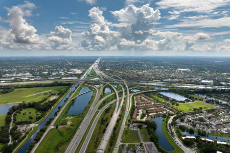 American highway multilevel road junction in Miami urban populated area. Wide freeway crossroads in Florida with fast driving cars. USA transportation infrastructureの写真素材