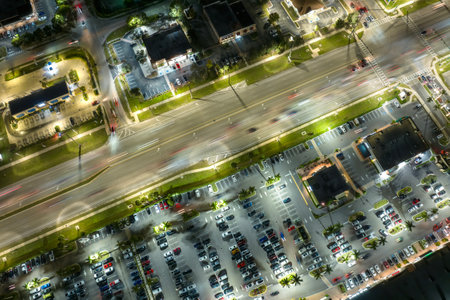 American wide road and strip mall plaza in North Port, Florida. Illuminated town traffic with driving cars at night. USA transportation infrastructure conceptの写真素材
