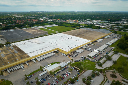 Big corporate shipment center with many cargo semi trucks unloading and uploading retail products for further retail shipment. Global market conceptの写真素材
