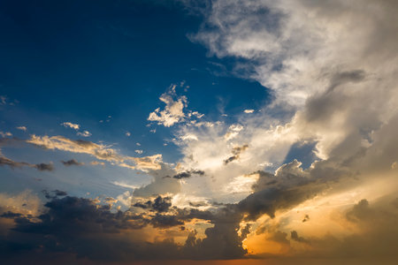 Bright sunset with setting sun behind vivid orange and yellow cloudsの写真素材