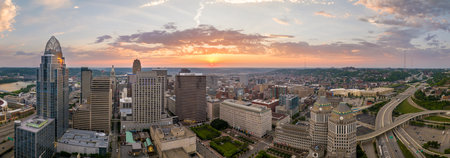 Cincinnati city, Ohio USA. View from above of brightly illuminated high skyscraper buildings in downtown district of American megapolis with business financial district at sunsetの写真素材