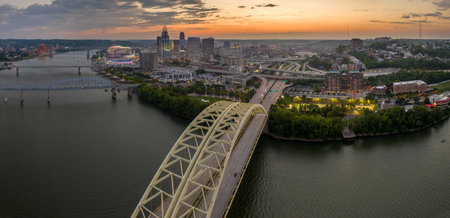 Daniel Carter Bridge in Cincinnati city, Ohio, USA with highway traffic driving cars in downtown district. American city skyline with brightly illuminated high commercial buildings at nightの写真素材