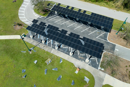 Destroyed by hurricane wind solar panels installed over parking lot canopy shade for parked cars for effective generation of clean energy. Damage from severe weather to Florida infrastructureの写真素材