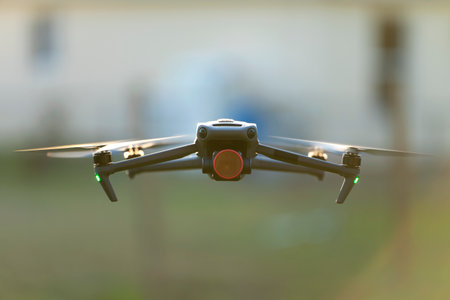Drone aircraft with blurred fast rotating propellers and video camera flying in airの写真素材