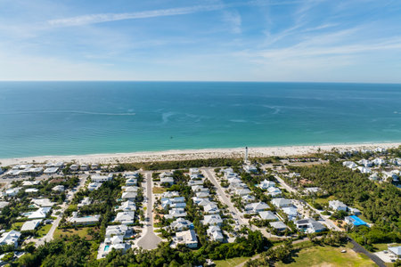 Expensive mansions between green palm trees on Gulf of Mexico shore in island small town Boca Grande on Gasparilla Island in southwest Florida, USA. Aerial view of wealthy waterfront neighborhoodの写真素材
