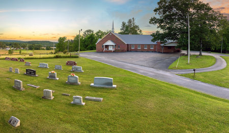 Old cemetery with grave stones on green grass lawn in American countryside town. Concept of deathの写真素材