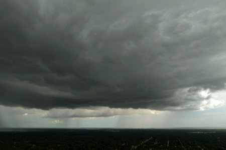 Rain shower water pouring down from stormy clouds during summer thunderstorm in Floridaの写真素材