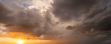Stormy cumulonimbus clouds before thunderstorm on dark sunset sky. Moving and changing cloudscape weatherの写真素材