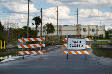 Warning roadworks sign and safety barrier on city street during maintenance repair workの写真素材