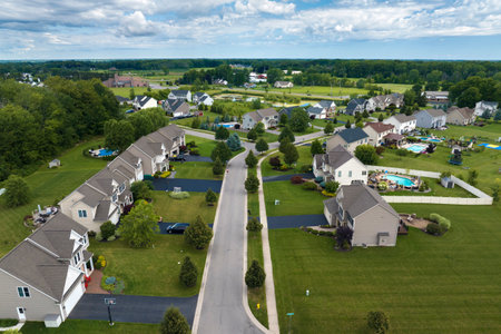 Aerial view of private residential houses in rural suburban sprawl area in Rochester, New York. Upscale suburban homes with large backyards and green grassy lawns in summer seasonの写真素材