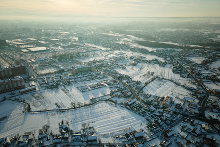 Aerial view of residential houses with snow covered roofops in suburban rural town area in winterの写真素材