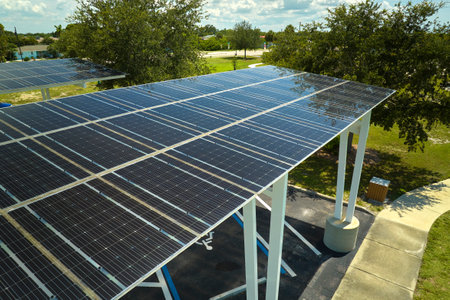 Aerial view of solar panels installed as shade roof over parking lot for parked cars for effective generation of clean electricity. Photovoltaic technology integrated in urban infrastructureの写真素材