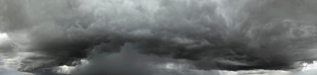 Heavy rain falling down from stormy clouds during thunderstorm on dark sky. Moving and changing cloudscape weatherの写真素材