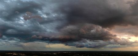 Heavy rain falling down from stormy clouds during thunderstorm on dark sky. Moving and changing cloudscape weatherの写真素材