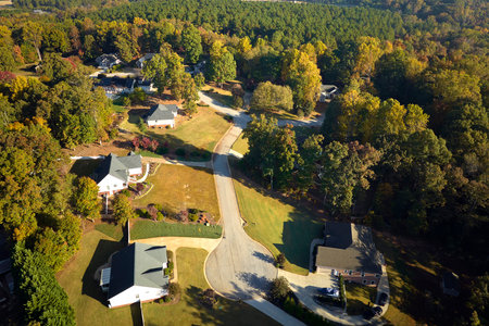 View from above of expensive residential houses between yellow fall trees in suburban area in South Carolina. American dream homes as example of real estate development in US suburbsの写真素材