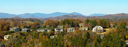 View from above of expensive residential houses high on hill top between yellow fall trees in suburban area in North Carolina. American dream homes as example of real estate development in US suburbsの写真素材