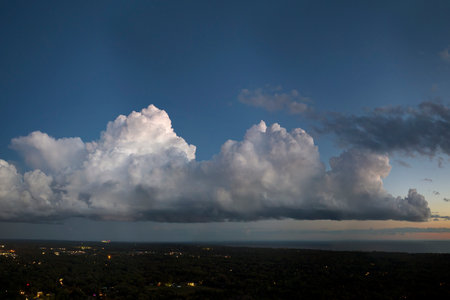 Dramatic sky covered with colorful clouds over dark ground. Panoramic skyscapeの写真素材