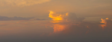 Dramatic sunset sky covered with colorful yellow clouds. Panoramic skyscapeの写真素材