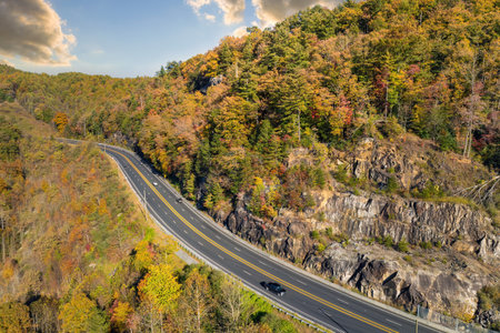 Freeway road with fast moving traffic cars and trucks in North Carolina Appalachian mountains in fall season. Interstate transportation infrastructure in USAの写真素材