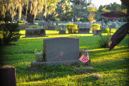 Grave tombstones in old cemetery in shade of southern oak trees on green grass in Orlando, Florida. Death conceptの写真素材
