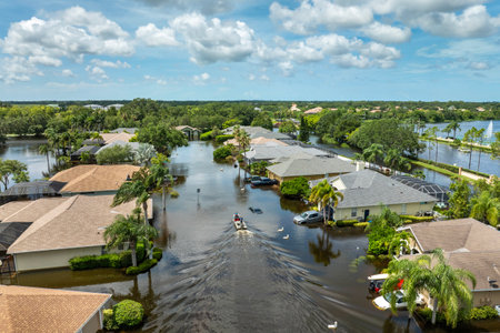 Hurricane Debby flooded street in Sarasota, Florida. Victims boating on rainfall flood waters between rural homes in residential areaの写真素材